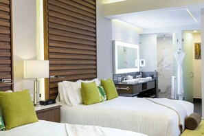 A hotel room with two beds, a large mirror, a vanity with a marble countertop, and a bathroom visible through an open door. - Garza Blanca Luxurious Oceanfront 3-Bedroom with Expansive Balcony and Jacuzzi (Cancún)