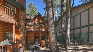A log cabin with a balcony, a covered patio, and a fenced yard. - Summit Timber | 3-Min Walk to Snow Summit (Big Bear Lake)