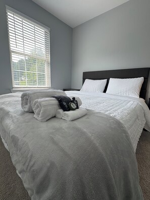 A hotel room with a large bed, a nightstand, and a window with blinds. - 3-bedrooms in quaint Dumfries with AC (Dumfries)