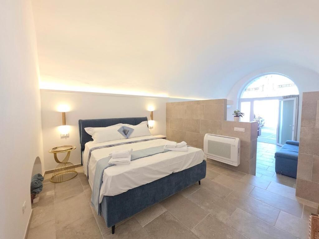 Ein Schlafzimmer mit einem Bett, Nachttischlampen, einem kleinen runden Tisch und einer Heizung.