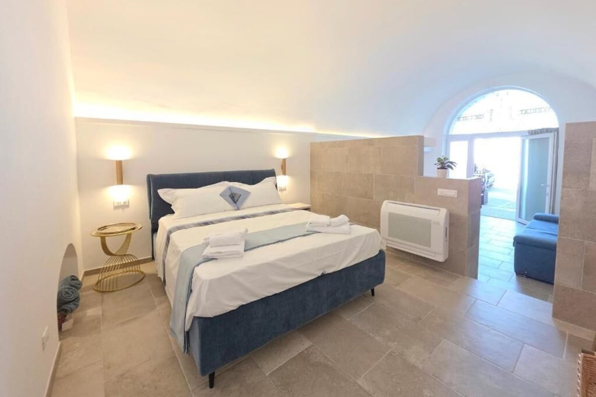 Ein Schlafzimmer mit einem Bett, Nachttischlampen, einem kleinen runden Tisch und einer Heizung.