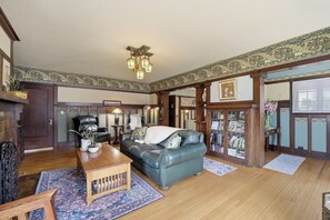 A traditional living room with a leather sofa, wooden coffee table, and patterned rugs. - Historic 3BR Monrovia Oasis with Pool, BBQ & Spa (Monrovia)