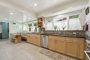 A modern kitchen with wooden cabinets, a built-in oven, and a dishwasher. - Historic 3BR Monrovia Oasis with Pool, BBQ & Spa (Monrovia)