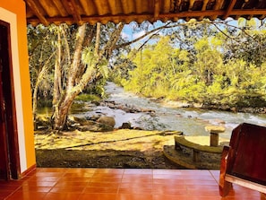 Vista de un río a través de una estructura de madera con piso de baldosas.