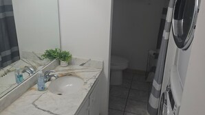 Kylpyhuone, jossa on pesuallas, peili ja wc.