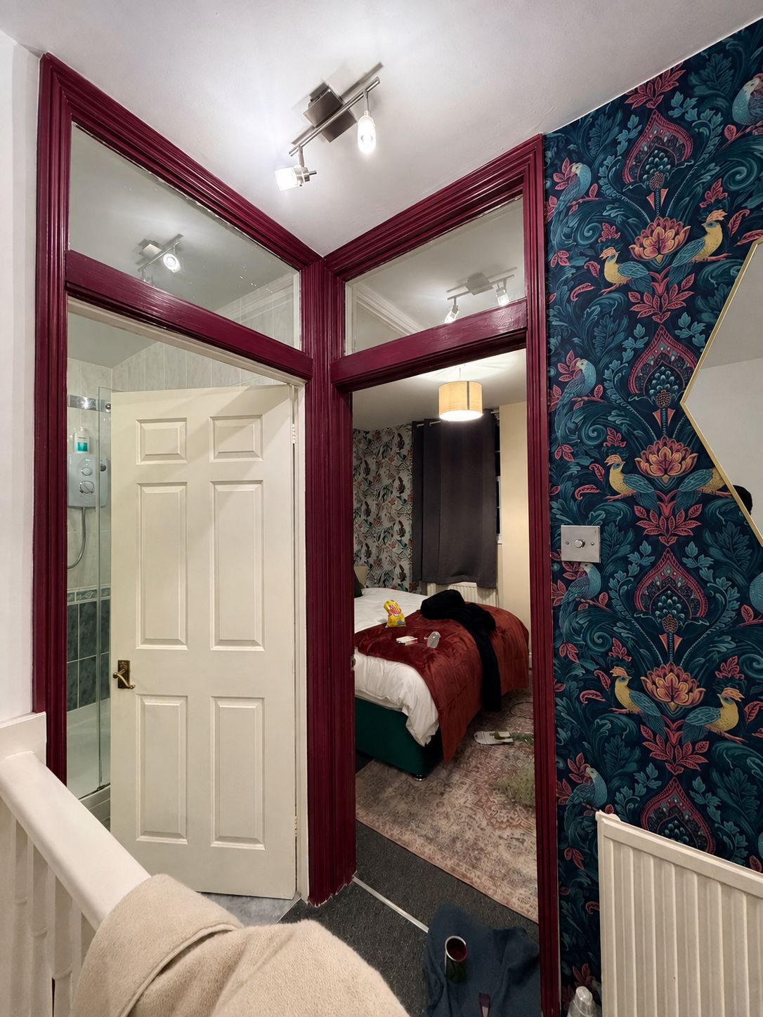 A bedroom with a bed, a mirror, and a door leading to a bathroom.