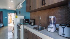 Eine moderne Küche mit Mikrowelle, Kaffeemaschine, Mixer, Toaster und Spüle.