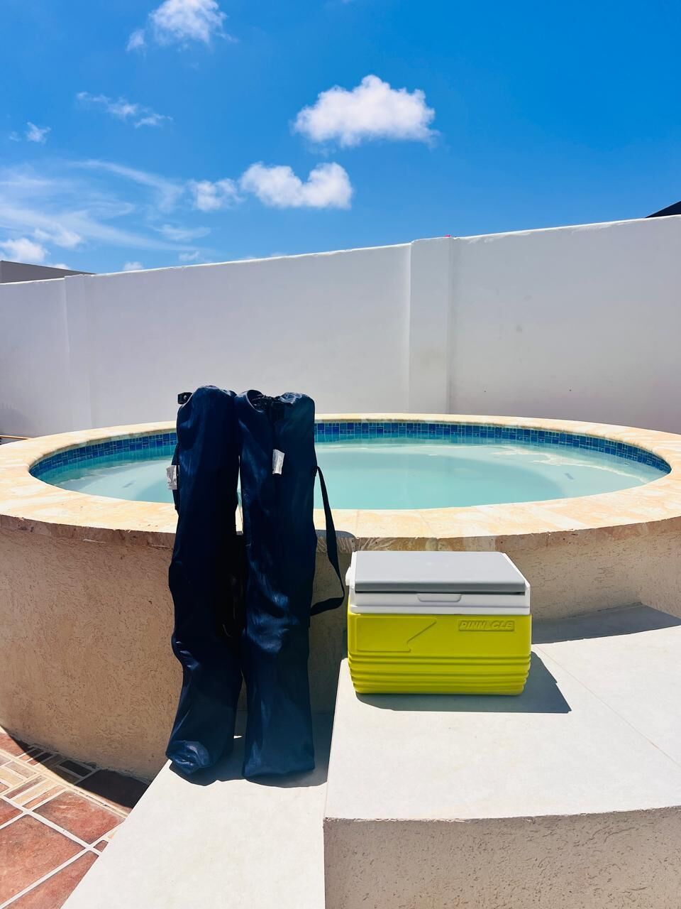Ein Schwimmbecken mit einer weißen Wand und blauem Himmel.