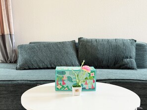 Una habitación con un sofá, una mesita y una planta en maceta.