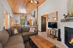 Ein modernes Wohnzimmer mit Ecksofa, einem Kamin, einem gitterförmigen Couchtisch und einem Fernseher.