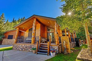 A log cabin with a stone foundation, wooden exterior, and a porch with steps leading to the entrance. - Perfect Moments at Moose Lodge Breckenridge Cabin on shuttle route (Breckenridge)