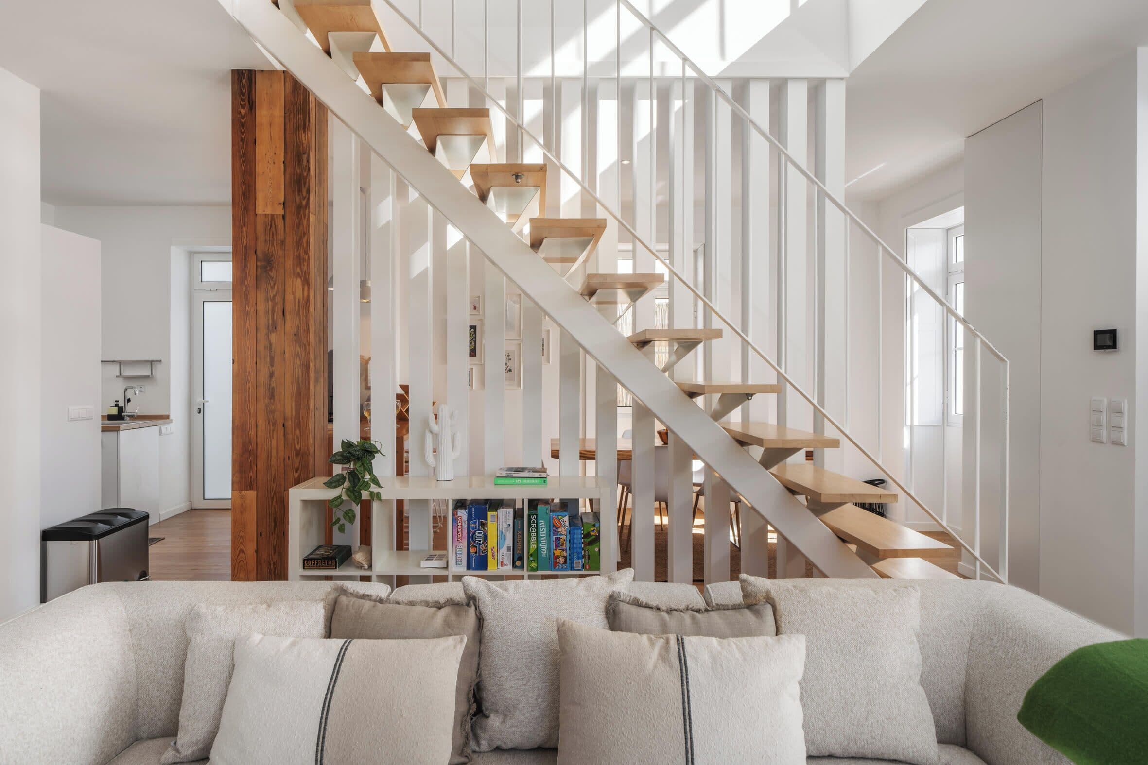 Ein modernes Interieur mit einer Treppe, einem Sofa und einem Bücherregal.