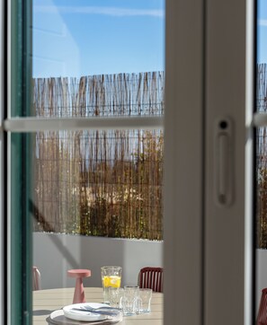 A dining area with a table set for two, a glass of water, and a glass with a lemon slice. - Traditional House – Cozy 3-bedroom house (Funchal)