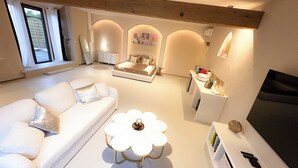 A modern living room with a white sofa, a coffee table, and a TV stand.