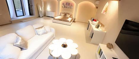 A modern living room with a white sofa, a coffee table, and a TV stand.