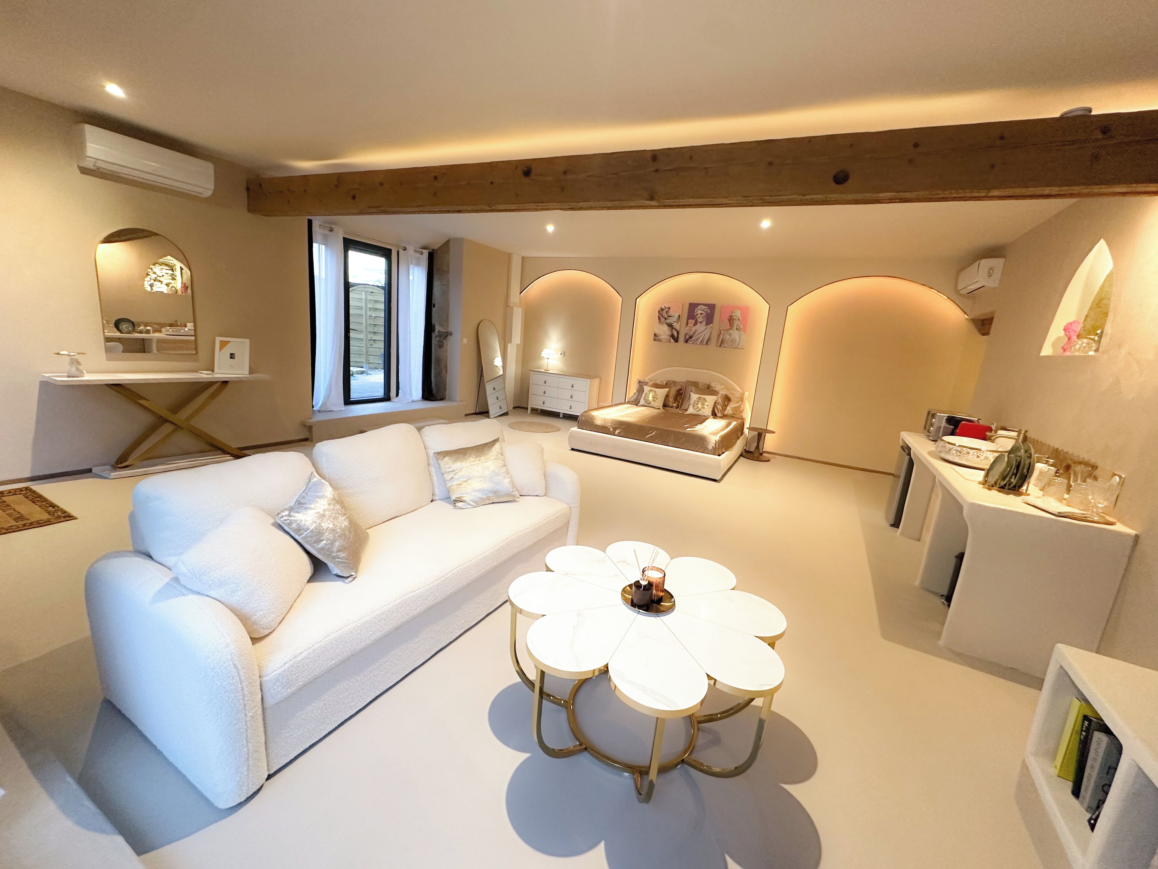 Een moderne woonkamer met een bank, een salontafel en een eethoek met een tafel en stoelen.