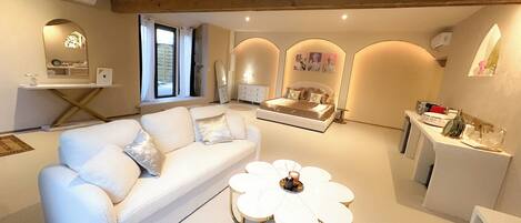 A modern living room with a sofa, a coffee table, and a dining area with a table and chairs.