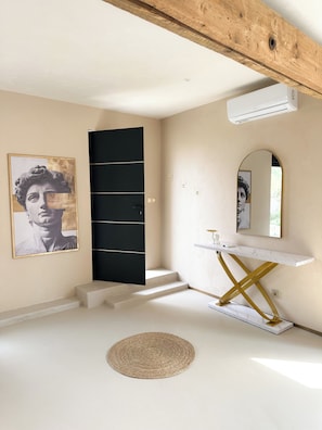 A modern bathroom with a white marble vanity, a black door, and a large mirror.