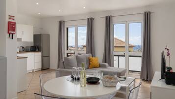 Ein modernes Apartment mit Essbereich, Küche und einem Balkon mit Blick.