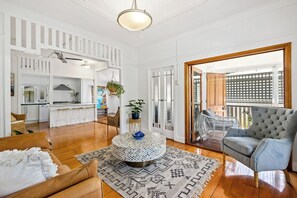 A spacious living area with a kitchen, a dining area, and a balcony with a view. - Classic Queenslander - walk to suncorp (Milton)