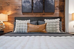 A bed with a dark headboard, two white fluffy pillows, and a brown leather pillow. - Views, Indoor Pool & Game Room  1 Mi to Downtown (Gatlinburg)