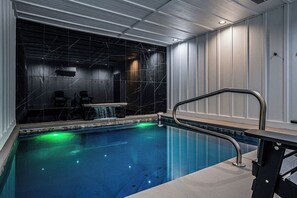 A swimming pool with a glass wall, a metal handrail, and a water feature. - Views, Indoor Pool & Game Room  1 Mi to Downtown (Gatlinburg)