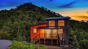 A two-story cabin with a balcony, surrounded by dense forest. - Views, Indoor Pool & Game Room  1 Mi to Downtown (Gatlinburg)