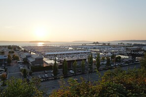 Un port de plaisance avec des bateaux amarrés, un parking et un pont en arrière-plan.