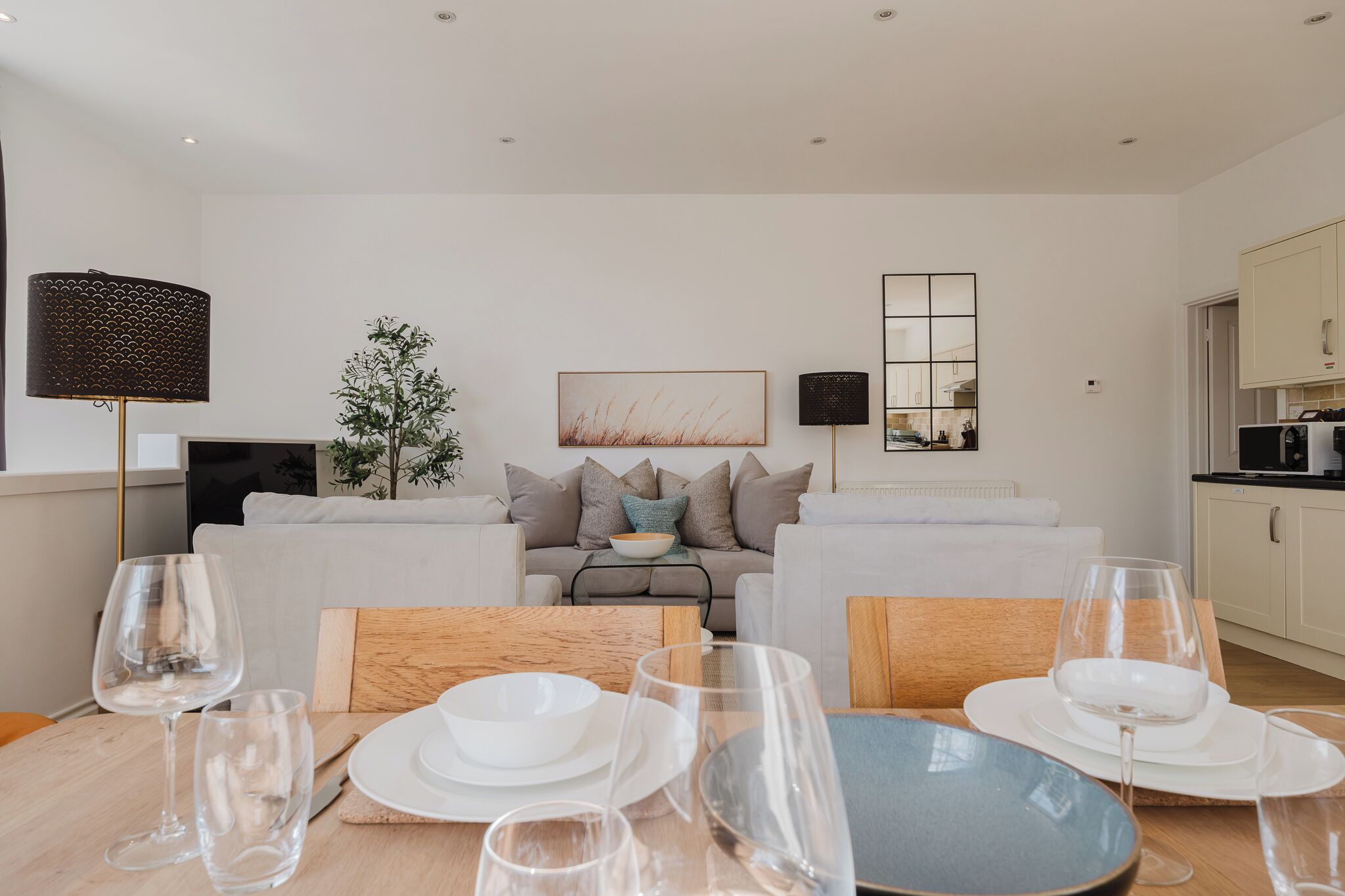Una sala de estar moderna con comedor, un juego de sofá, una mesa de centro y una cocina visible al fondo.