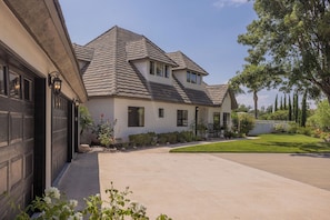 A two-story house with a garage, a driveway, and a well-maintained lawn. - Main Home at Chateau Blanc 5 bedroom/pool/spa, fire pit, views! (Temecula)