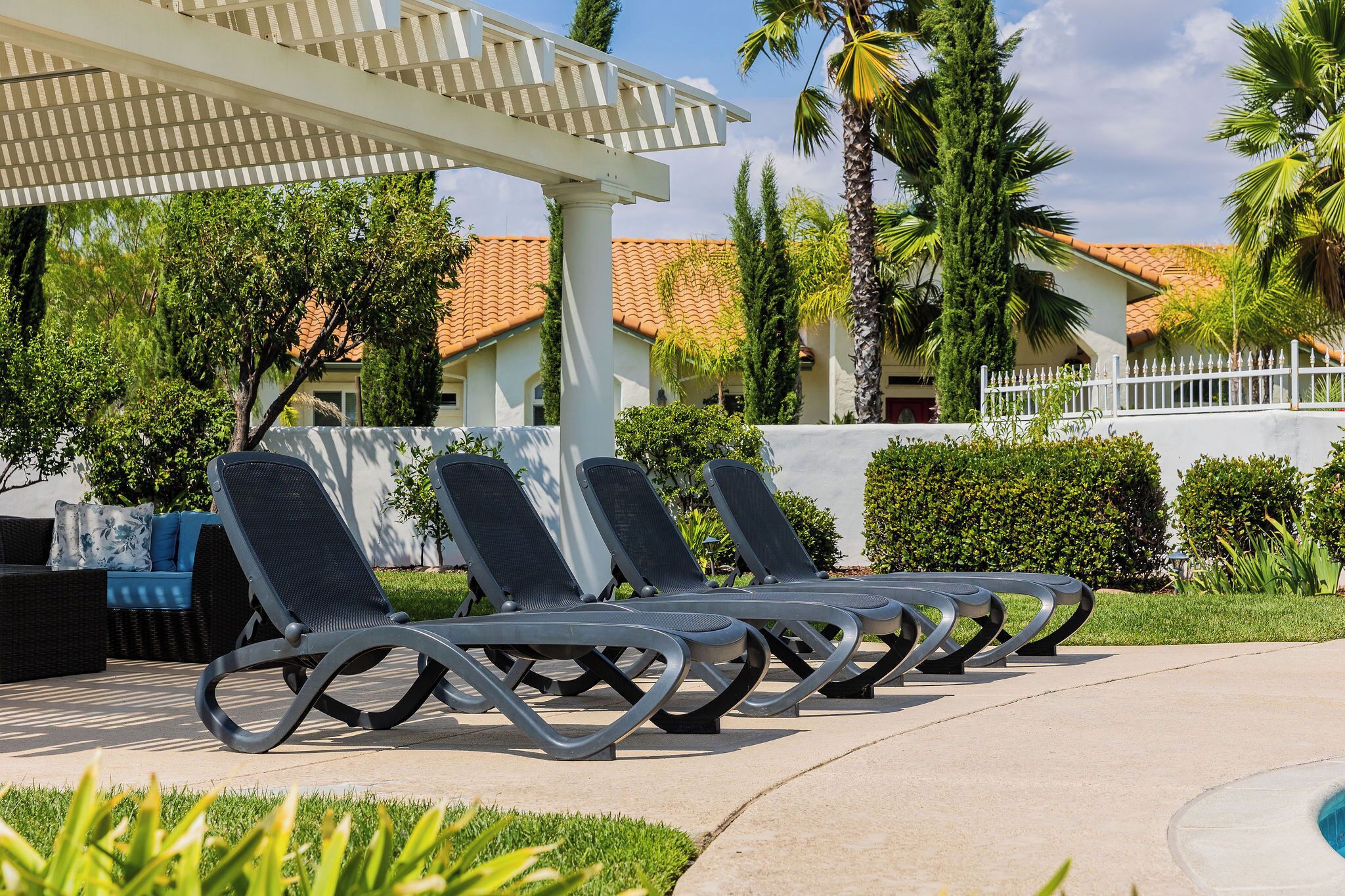 Un espace aménagé au bord de la piscine, avec des chaises longues et une pergola.