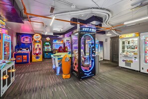 A brightly lit arcade with various gaming machines, including a claw machine and a basketball game. - Luxury Westgate 2BR | Canyons Village | Pools, Spa & Ski Valet (Park City)