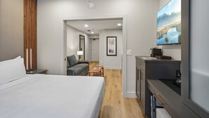 A hotel room with a bed, a desk, a chair, a TV, and a view of a mountain landscape. - Westgate Studio | Ski-In/Ski-Out | Pools, Spa & Ski Valet (Park City)