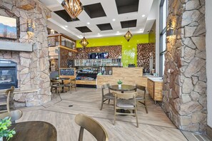 A restaurant with a stone wall, wooden furniture, and a bright green accent wall. - Westgate Studio | Ski-In/Ski-Out | Pools, Spa & Ski Valet (Park City)