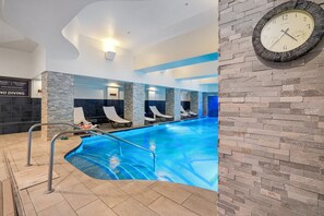 An indoor swimming pool with lounge chairs, a clock on the wall, and a sign indicating no diving. - Westgate Studio | Ski-In/Ski-Out | Pools, Spa & Ski Valet (Park City)