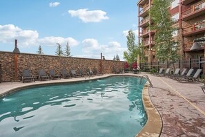 A swimming pool with lounge chairs and a stone wall. - Westgate Studio | Ski-In/Ski-Out | Pools, Spa & Ski Valet (Park City)
