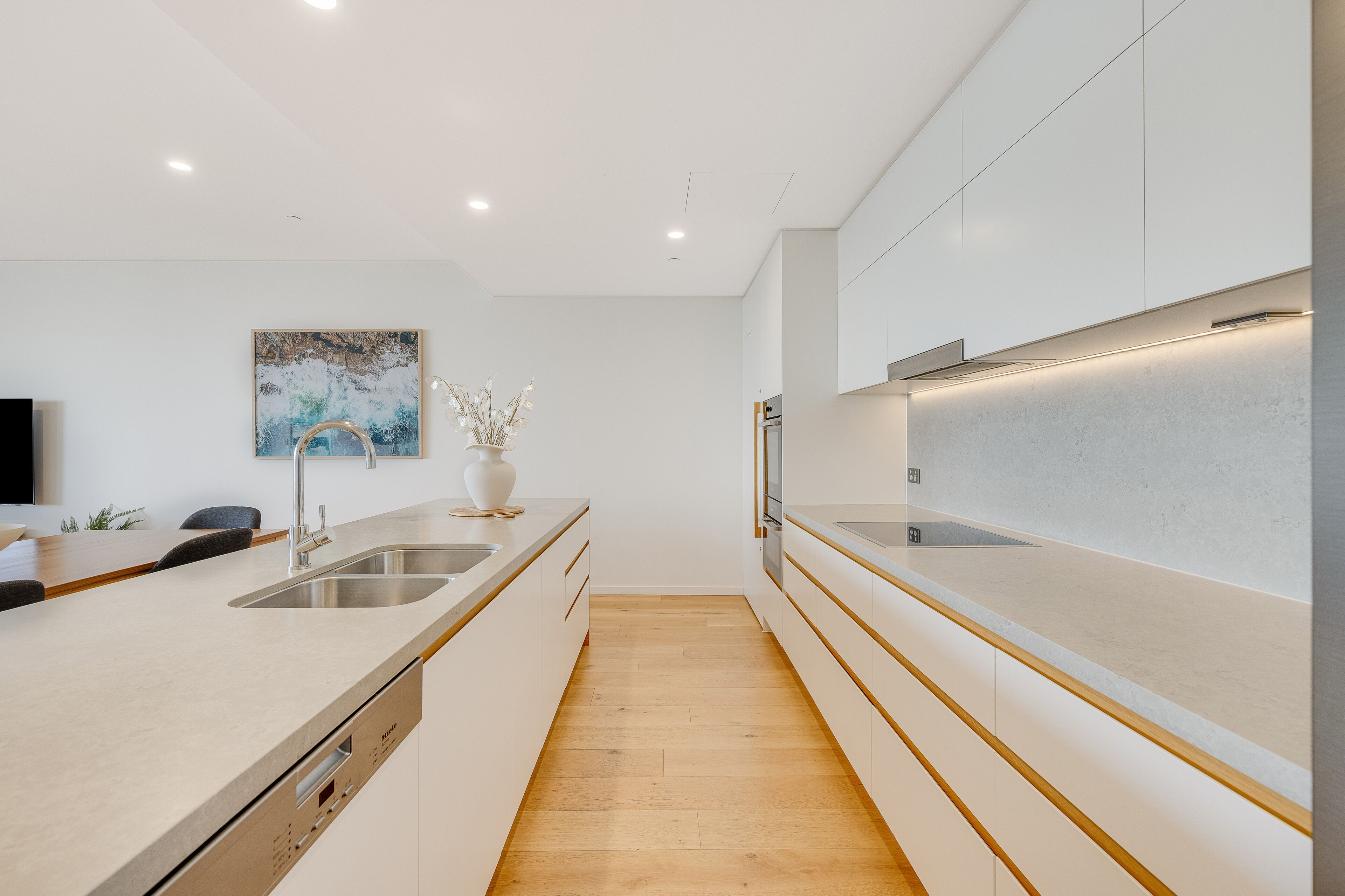 A modern kitchen with a central island, stainless steel appliances, and a minimalist design.