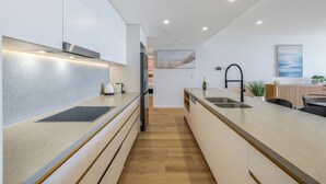 Una cocina moderna con una isla central, electrodomésticos integrados y un diseño minimalista.