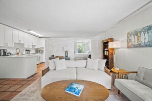 Ein modernes Wohnzimmer mit einer Couch, einem Couchtisch und einem Bücherregal.