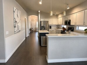 A modern kitchen with white cabinetry, stainless steel appliances, and pendant lighting. - Gilbert Oasis • Near Downtown Gilbert • King Suite • Private Yard & Grill (Gilbert)