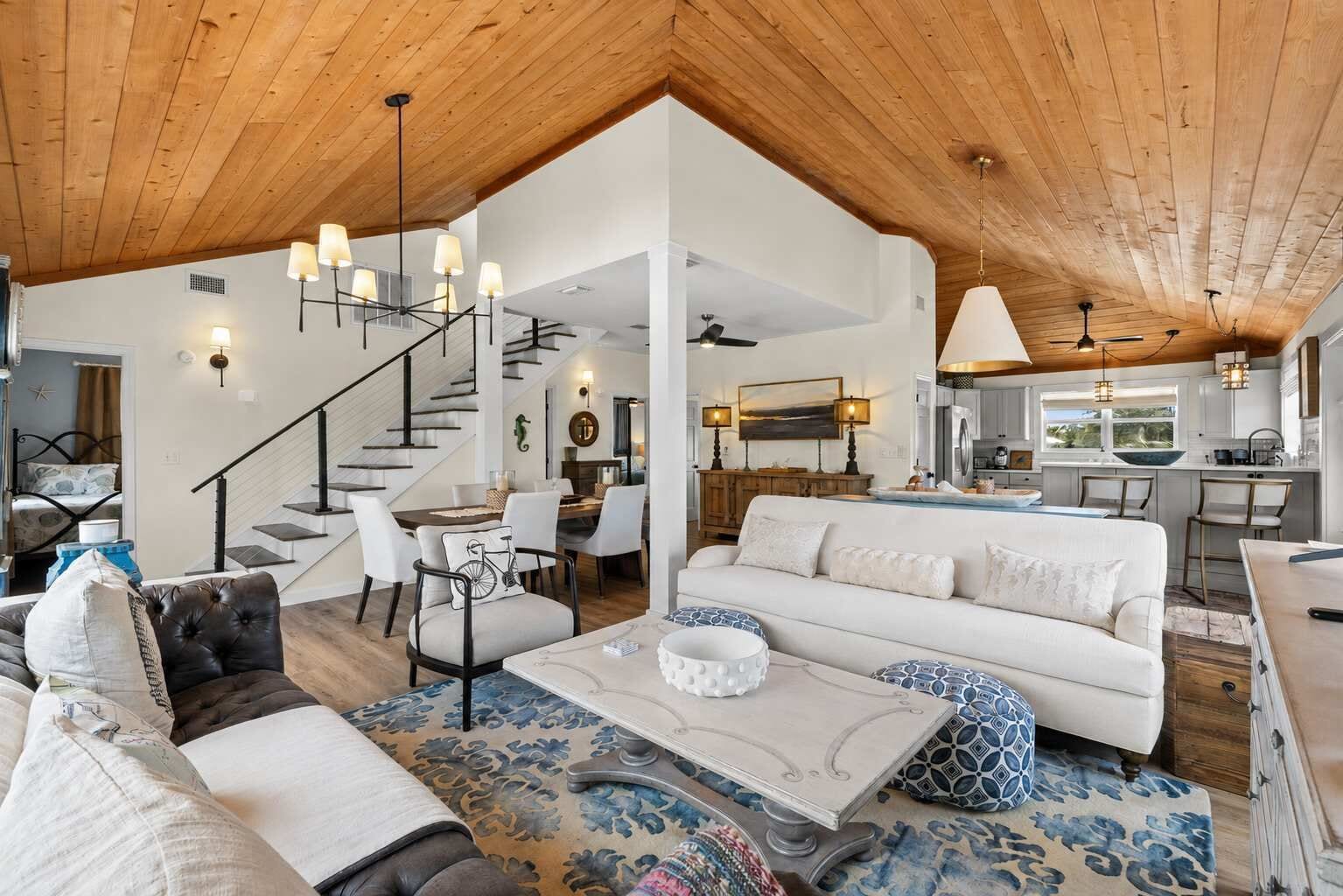 A spacious living area with a high ceiling, a dining area, and a kitchen.