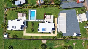 A residential property with two detached houses, a swimming pool, and a covered parking area. - Beach Lote Villas - Villa 1 +Pool-  Islote (Arecibo)