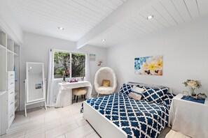 A bedroom with a bed, a chair, a desk, and a wardrobe. - Sun-Drenched Coastal Haven with Private Pool (Newport Beach)