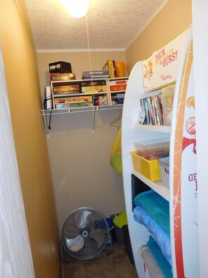 A small room with a bookshelf, a fan, and a bunk bed. - Affordable 3 bedroom Beach House in Murrells Inlet (Murrells Inlet)