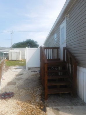 A residential property with a wooden staircase leading to a porch, a white fence, and a clear sky. - Affordable 3 bedroom Beach House in Murrells Inlet (Murrells Inlet)