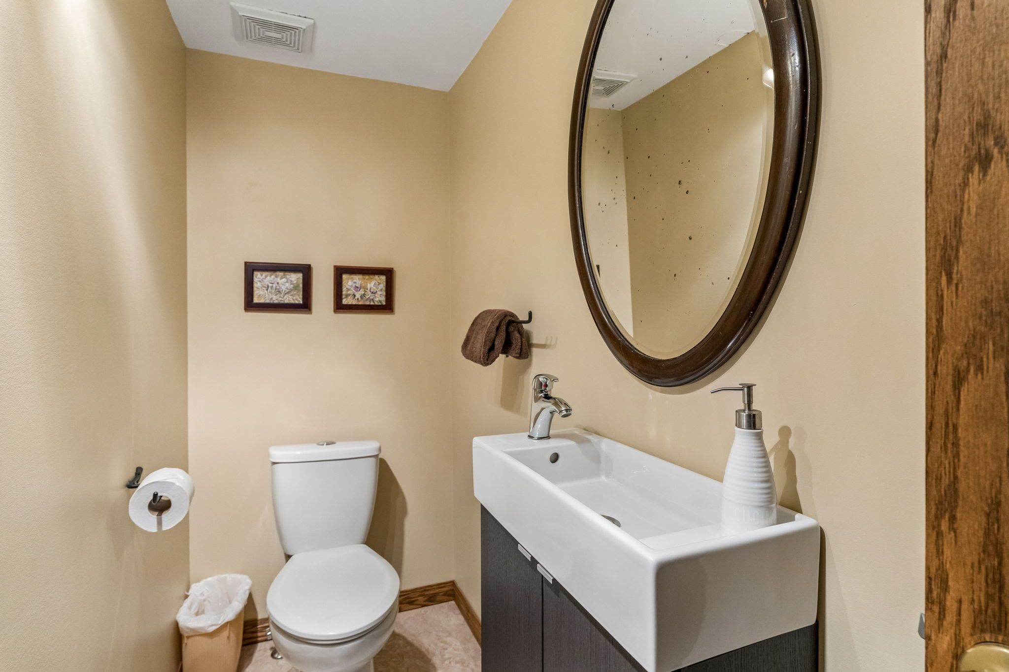 Un baño con inodoro, lavamanos y espejo.