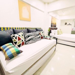 A modern bedroom with a bed, a sofa, and a small table.
