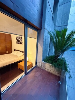 A modern bedroom with a bed, a nightstand, and a wall-mounted light fixture. - Apartment just a few steps from the Angel of Independence / Reforma, with parking (Ciudad de México)