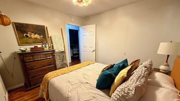Un dormitorio con cama, cómoda y un cuadro en la pared.