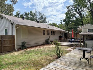 A residential property with a detached garage, a covered patio area with outdoor furniture, and a wooden deck. - Cozy  vintage style 3 bedroom  1 bath home in beautiful Water Valley (Water Valley)